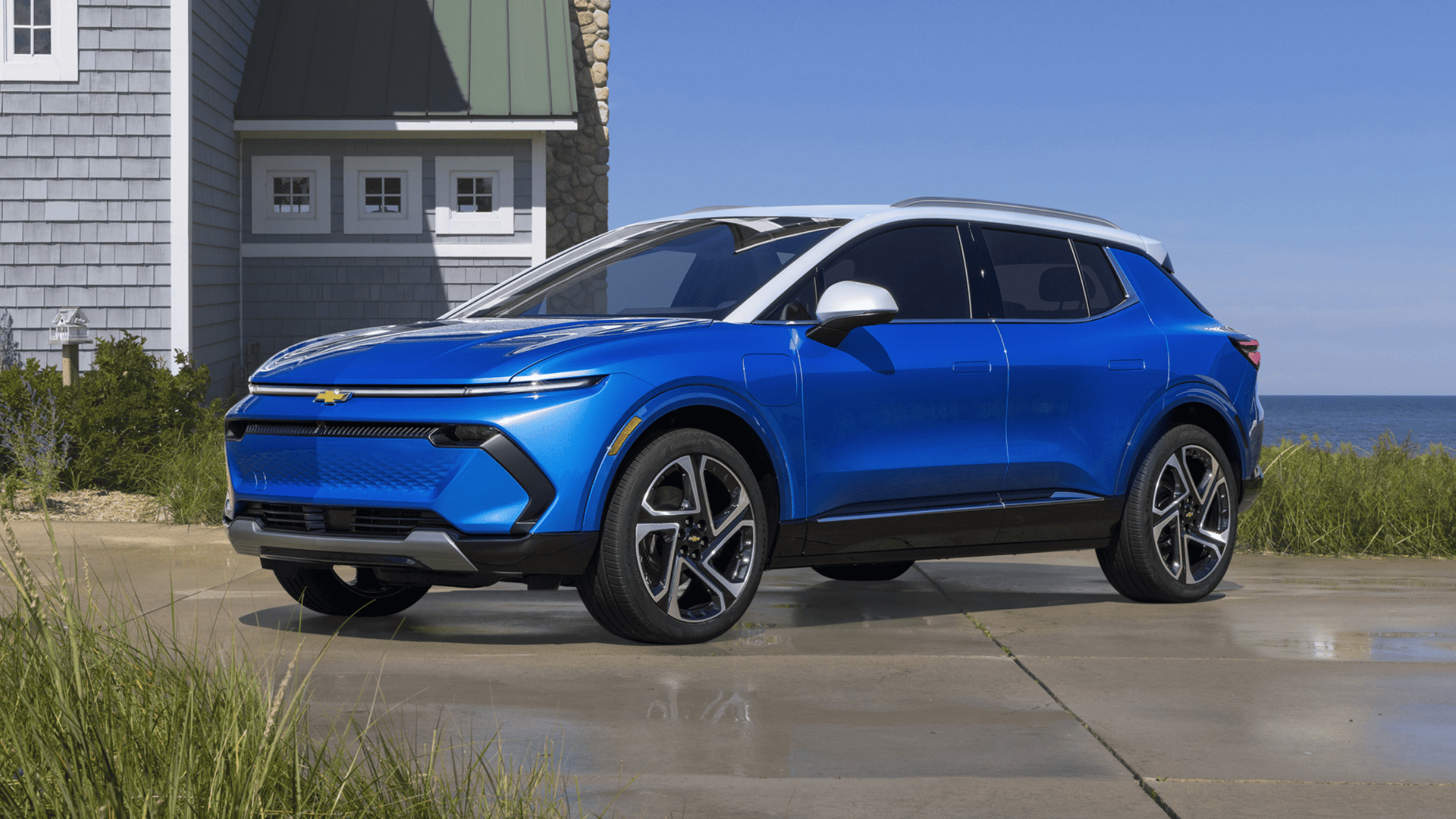 2025 Chevrolet Equinox EV parked by a coastal house with ocean in the background