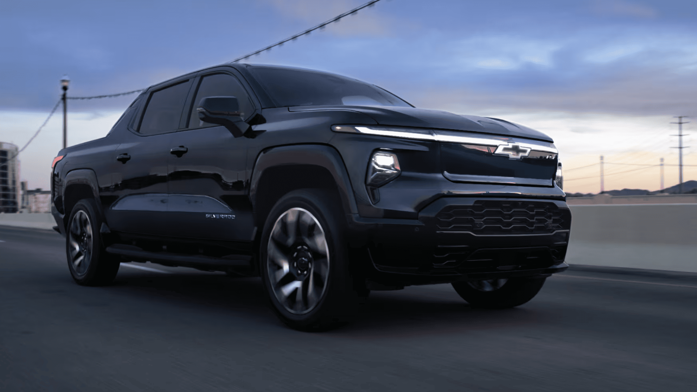2025 Chevrolet Silverado EV driving on a road during sunset