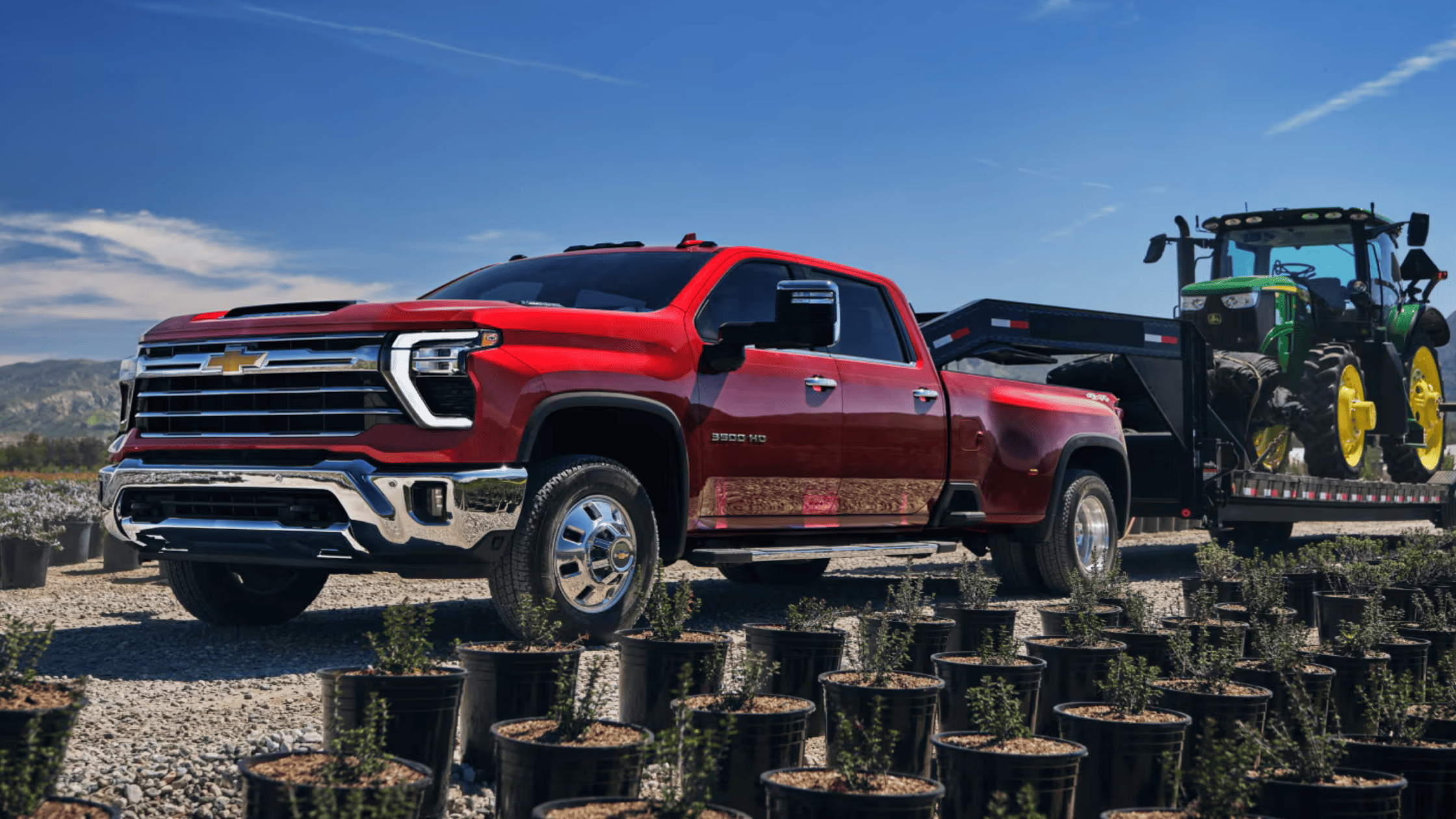 2025 Chevy Silverado 3500 HD towing tractor near nursery fields in West Jefferson, NC