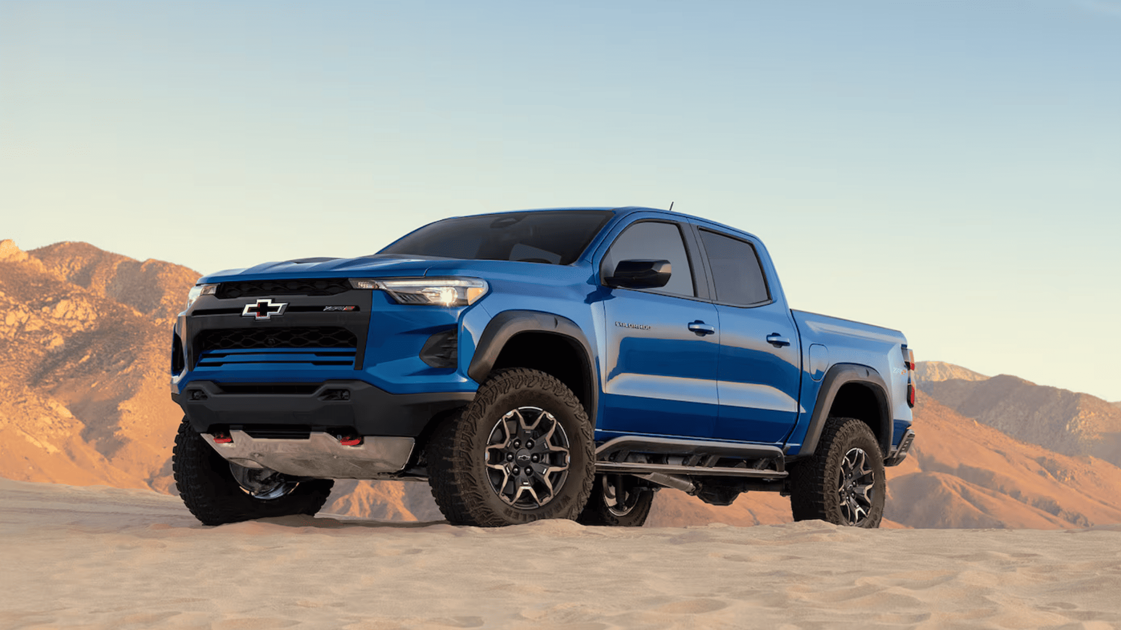 Bold blue 2025 Chevrolet Colorado ZR2 off-road pickup parked in desert terrain near West Jefferson, NC.