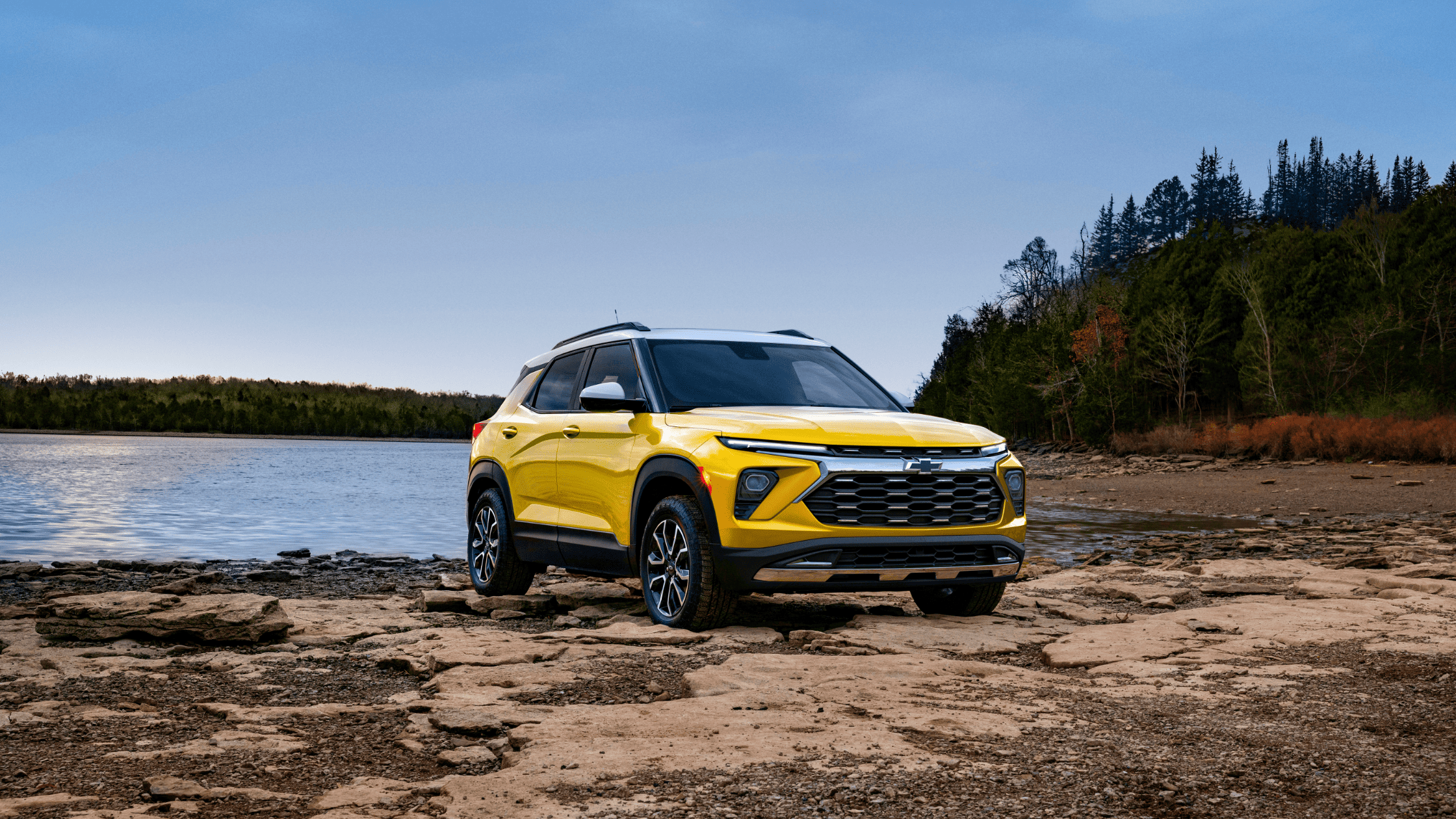 Bright yellow 2025 Chevrolet Trailblazer parked near a lakeside trail outside West Jefferson, NC, showcasing its sporty exterior and adventure-ready appeal.
