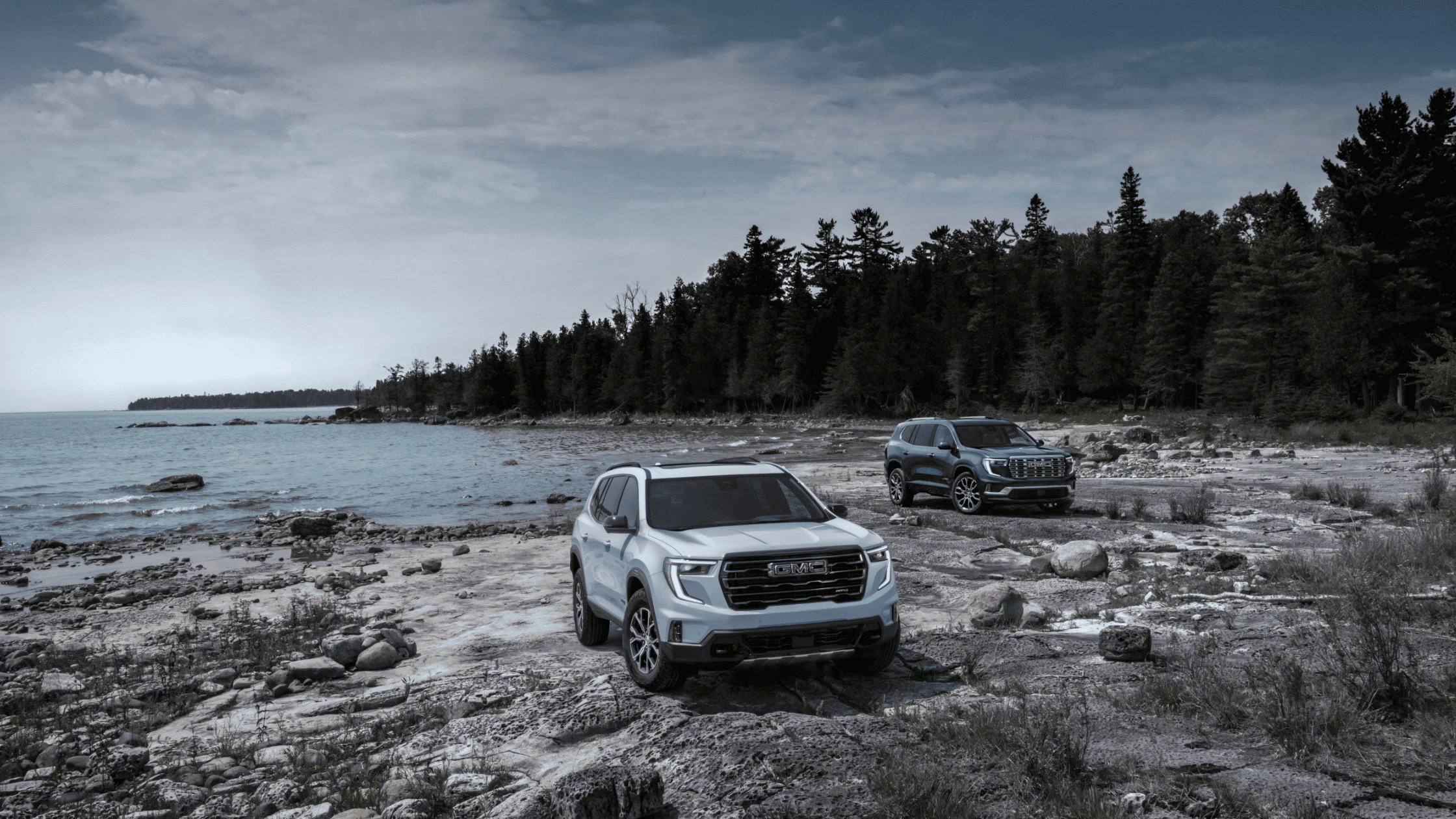 2025 GMC Acadia SUVs parked by a rocky lakefront shoreline near Morganton, NC.
