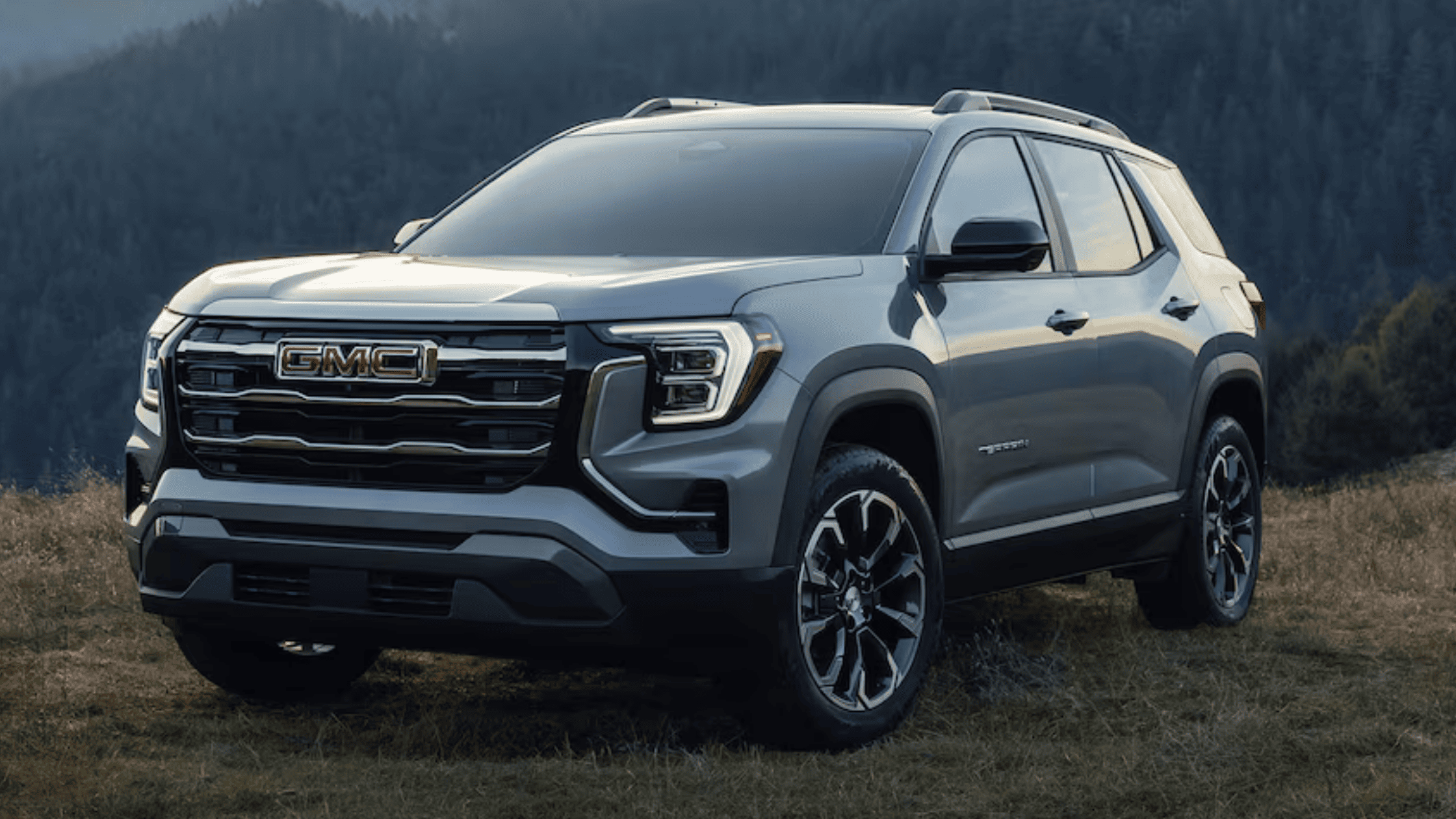 2025 GMC Terrain in gray parked in a scenic mountain setting near Morganton, NC, highlighting its sleek design and tech-forward features.