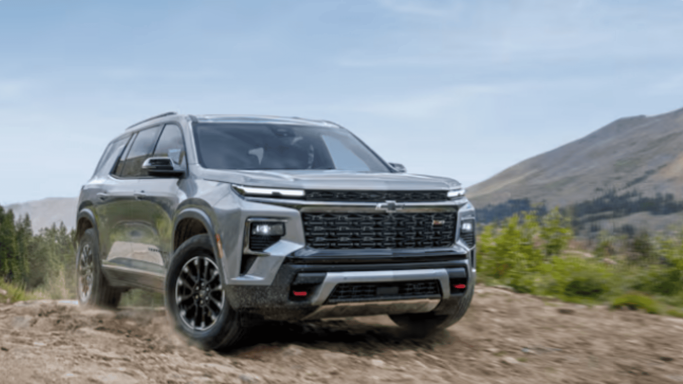 2026 Chevrolet Traverse driving off-road on rocky terrain near Morganton NC, showcasing its rugged capability.
