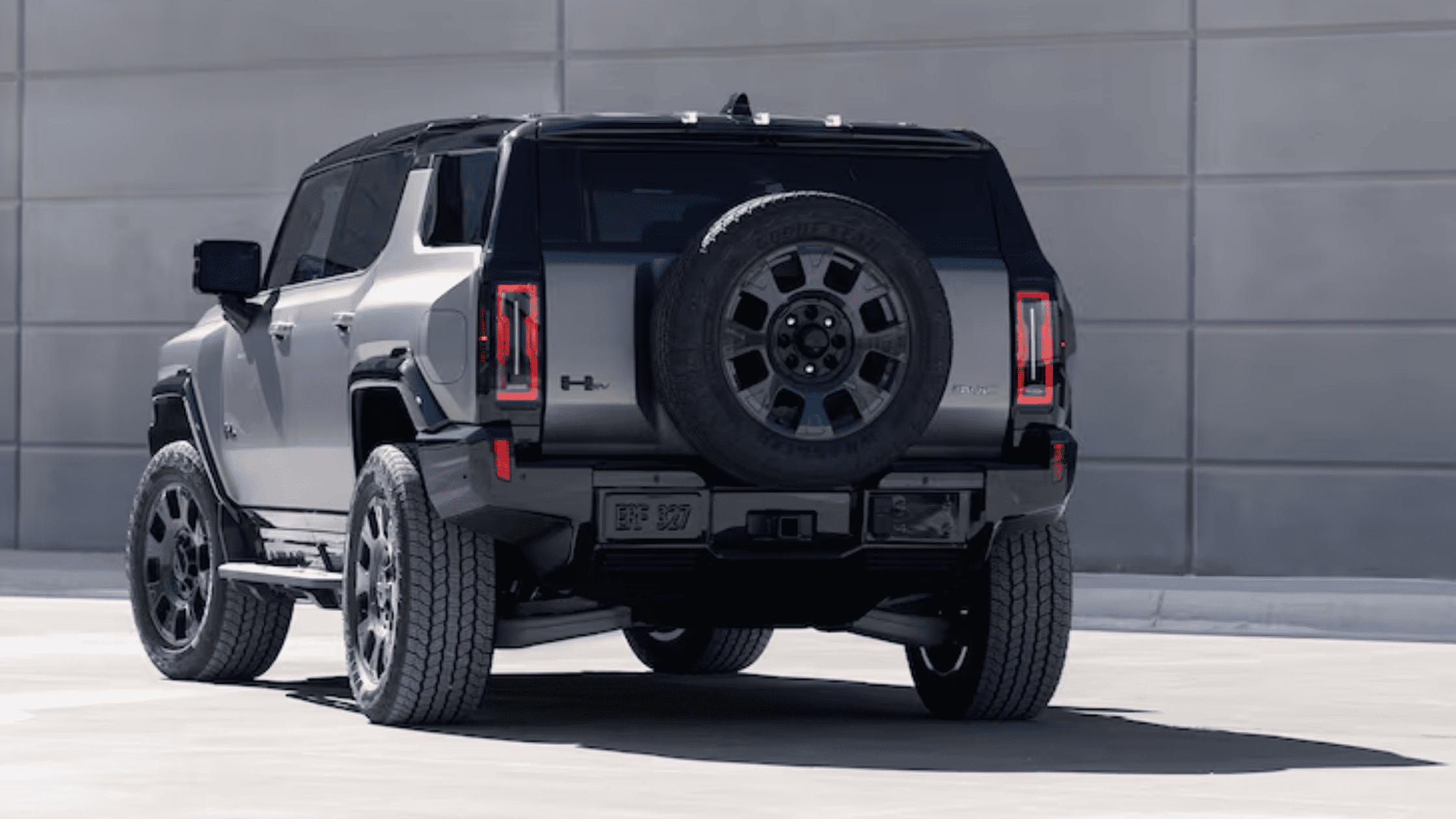 Rear view of the 2026 GMC Hummer EV SUV, featuring spare tire mount, wide off-road tires, and rugged electric SUV styling.