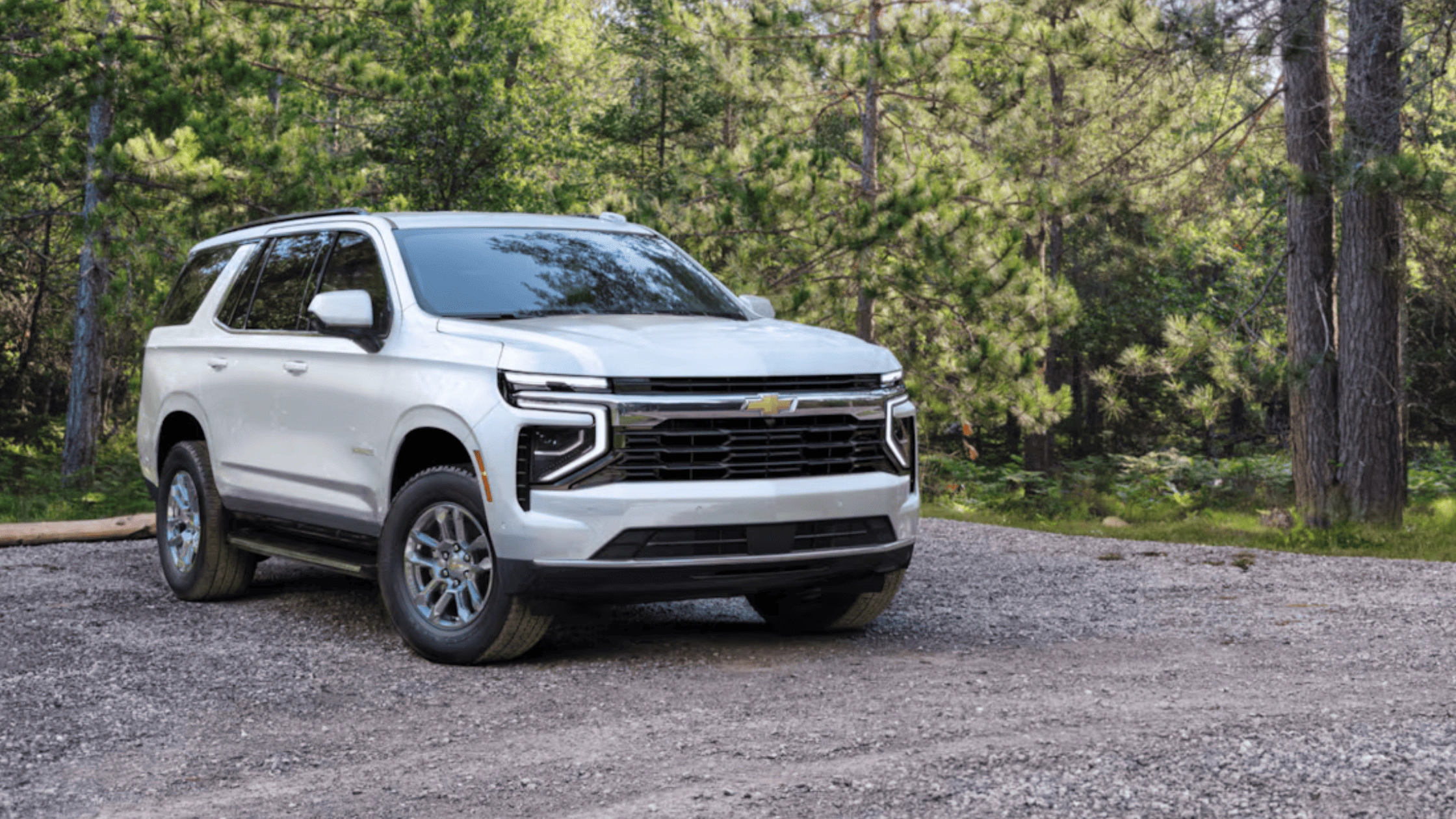 Why Morganton NC Families Like the Space and Safety of the 2026 Chevrolet Tahoe – white Chevrolet Tahoe SUV parked on a gravel path surrounded by trees, highlighting family-friendly size and modern exterior design.