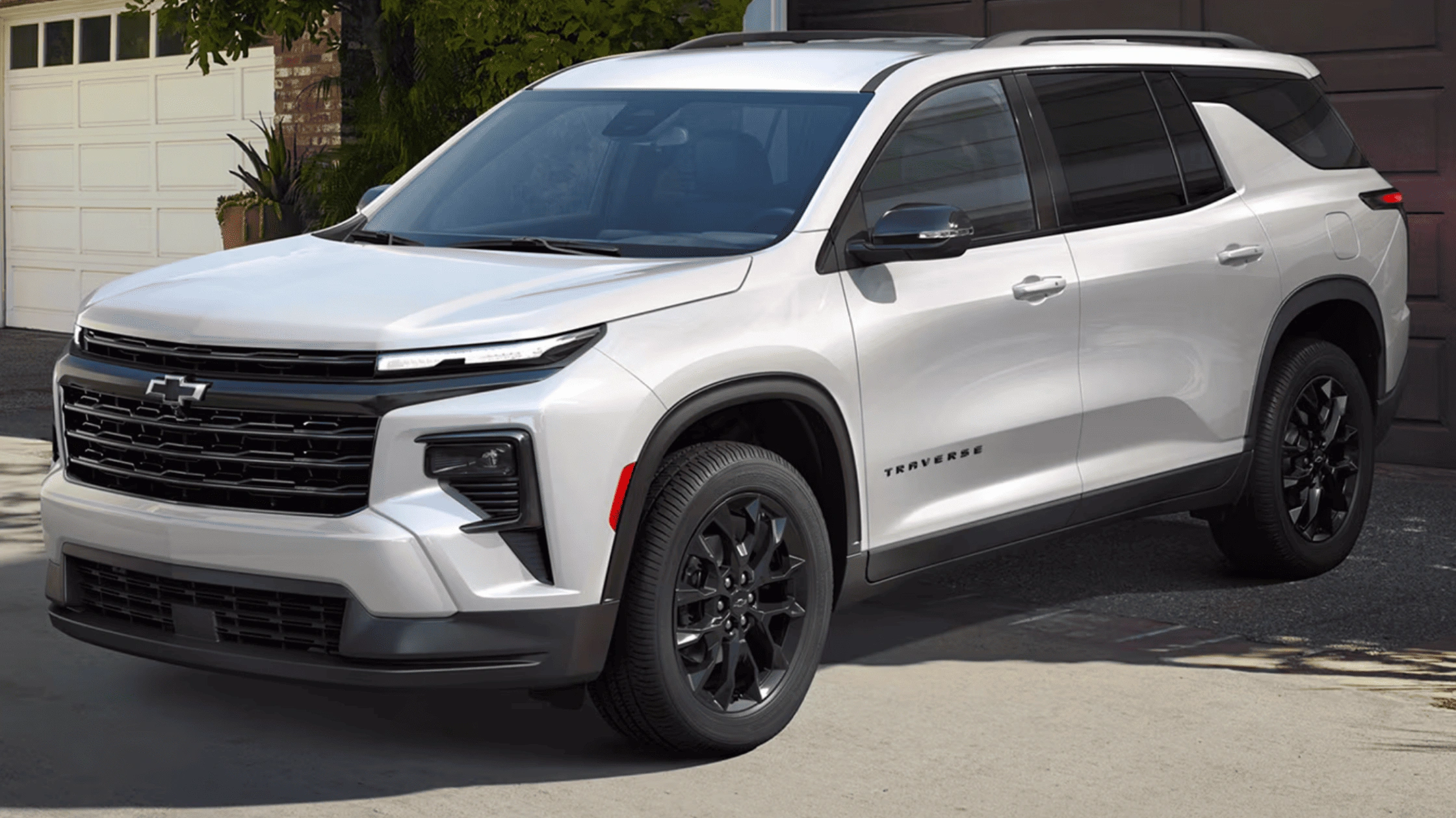 2026 Chevrolet Traverse three-row family SUV in white with black accents and wheels parked in residential driveway in Boone NC