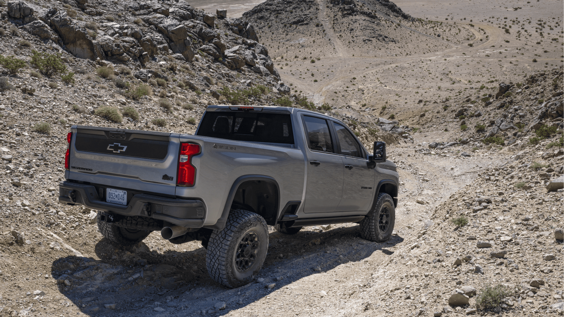 Chevrolet Silverado ZR2 driving on rocky trail in an off-road desert setting.