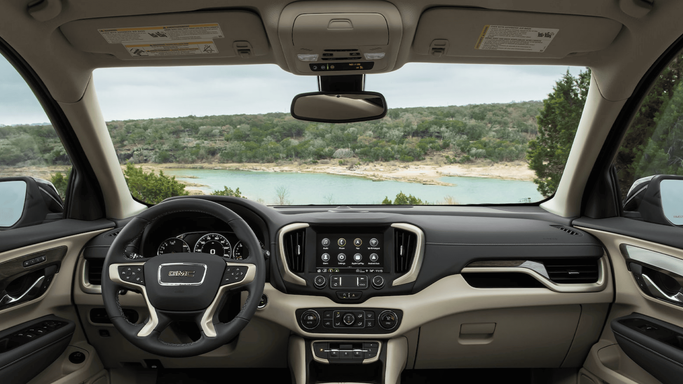 Interior view of GMC Terrain with two-tone dash and lake scenery through windshield.
