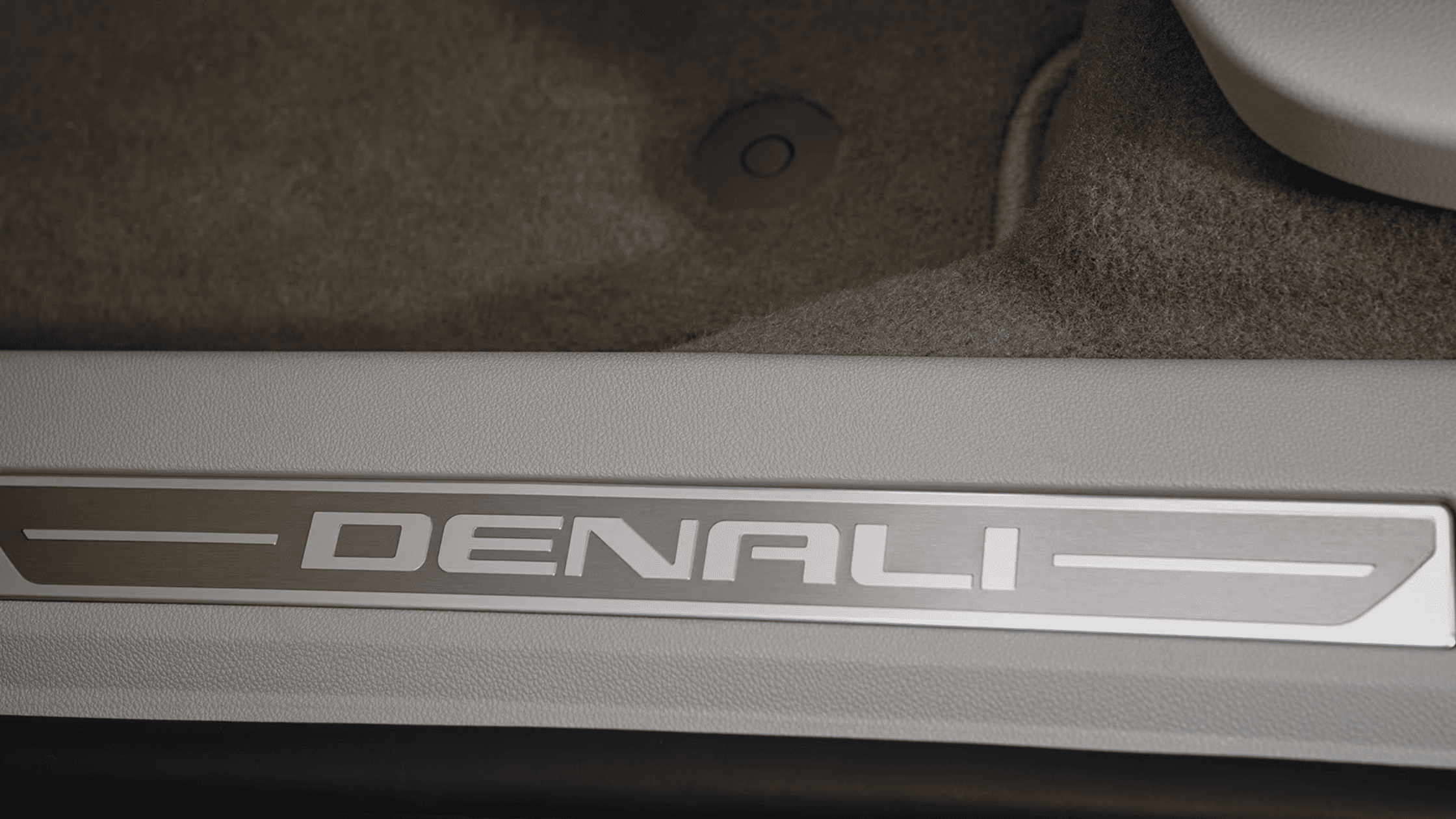 Close-up of GMC Denali badging on interior door sill trim