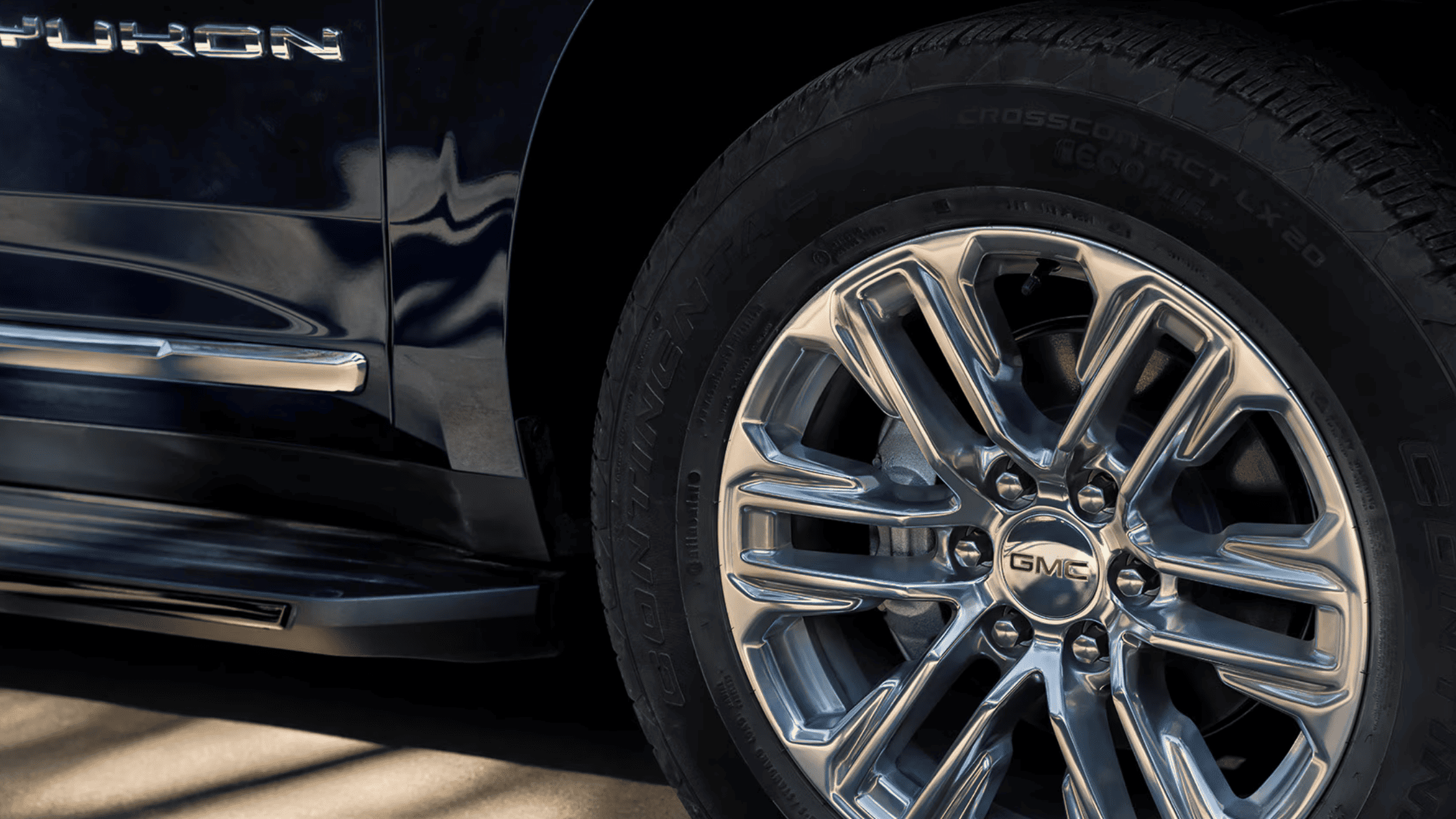 Chrome wheel and GMC badge on the 2024 GMC Yukon with Yukon branding on the body.