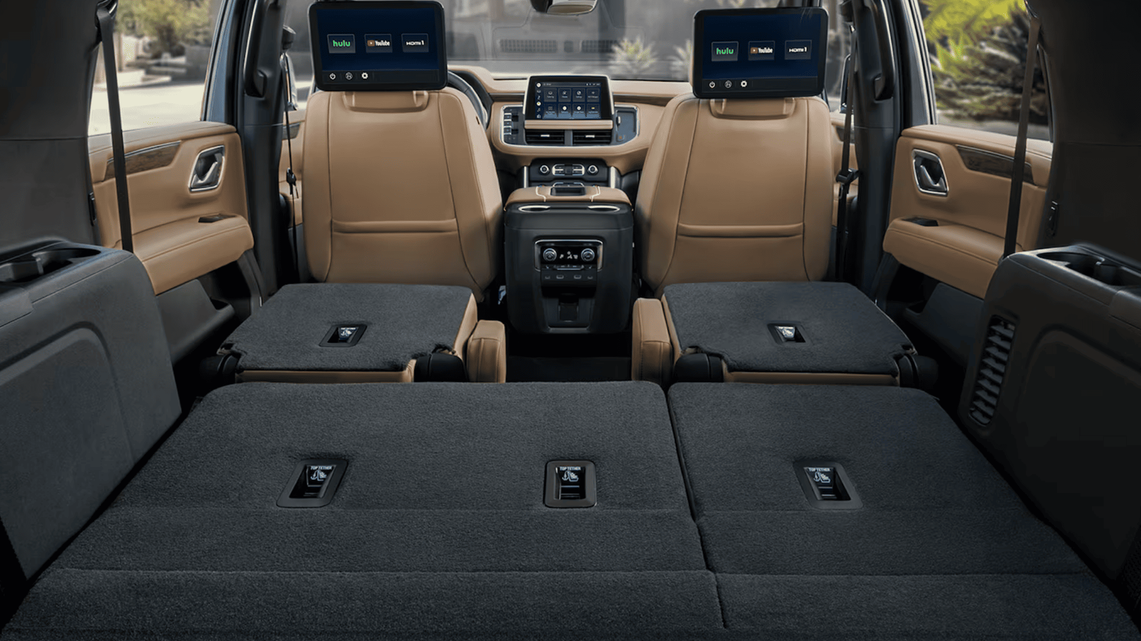 2024 Suburban cabin showing folded rear seats and entertainment screens on front headrests.