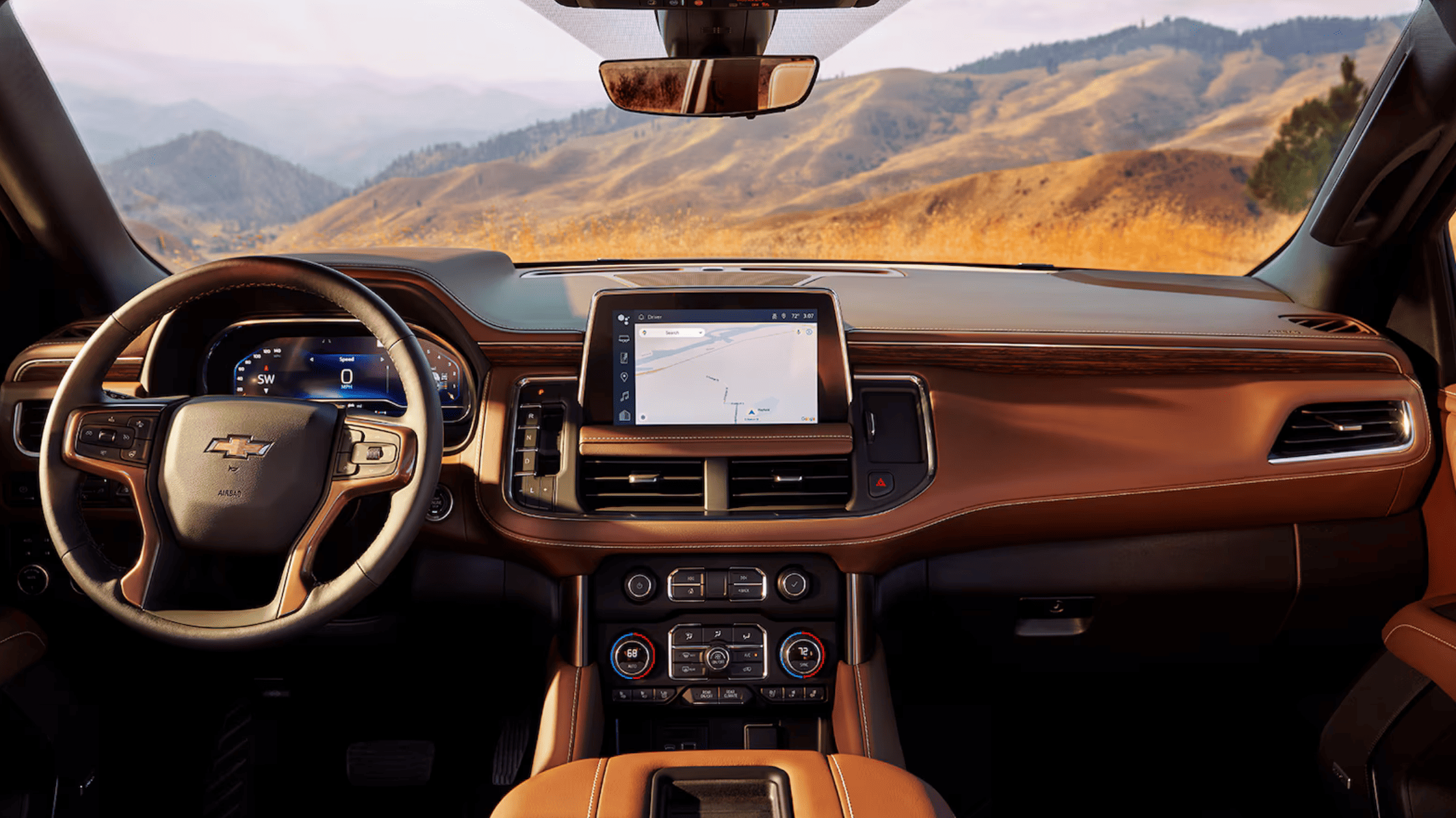 Front dashboard view of 2024 Suburban with brown leather interior and navigation screen.