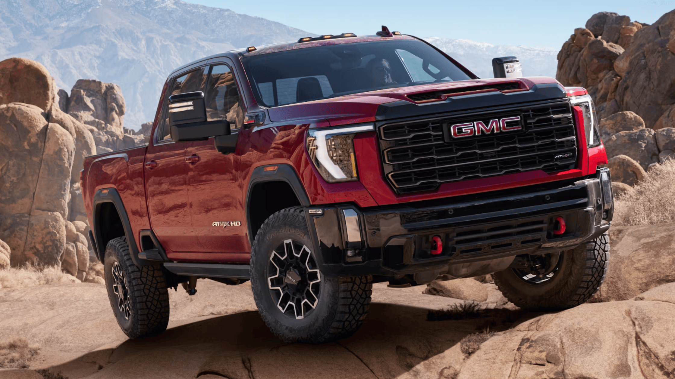 2024 GMC Sierra 2500 HD AT4X climbing rocks in rugged mountain terrain