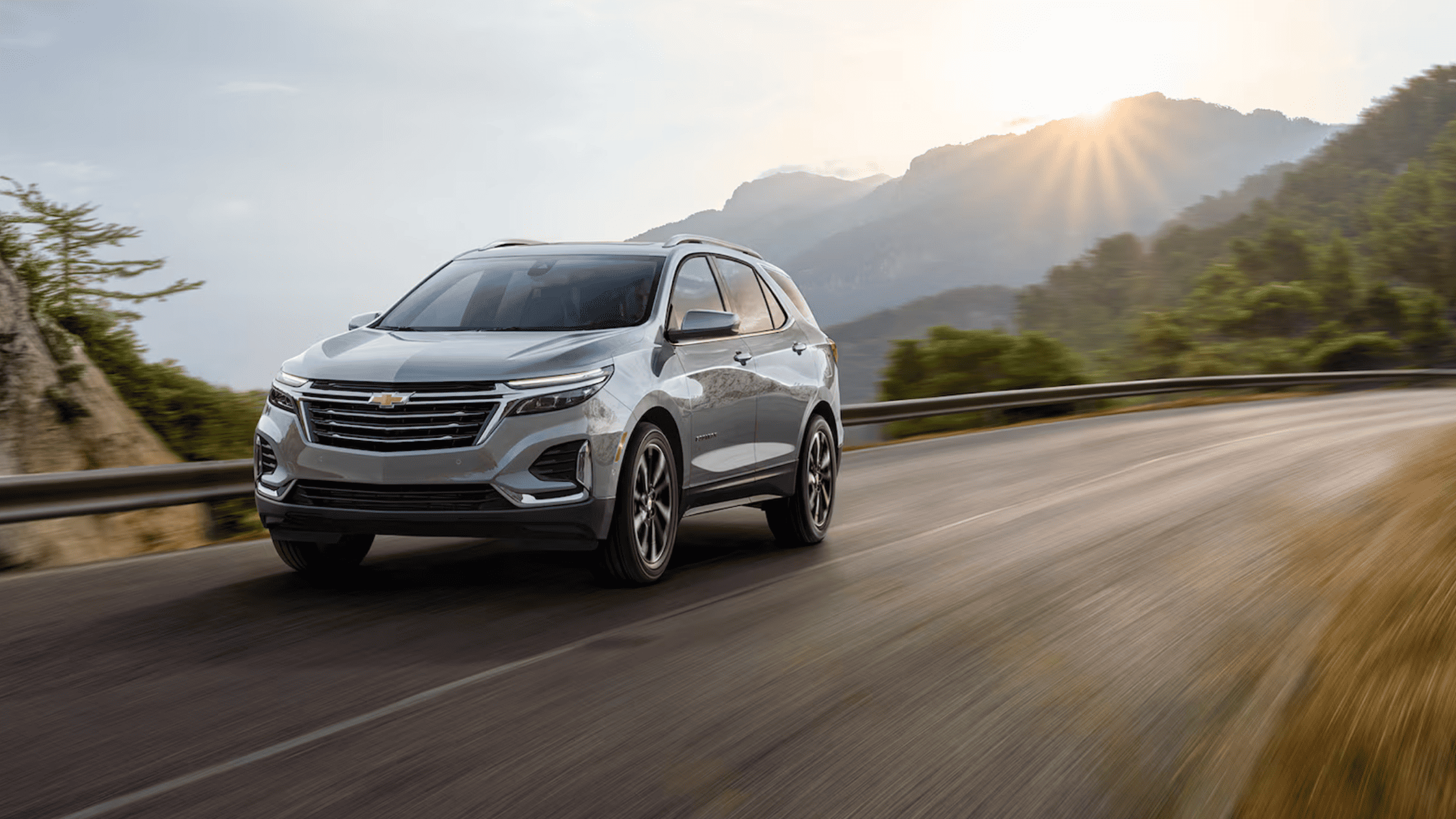 2025 Chevrolet Equinox driving on a mountain road at sunrise with motion blur