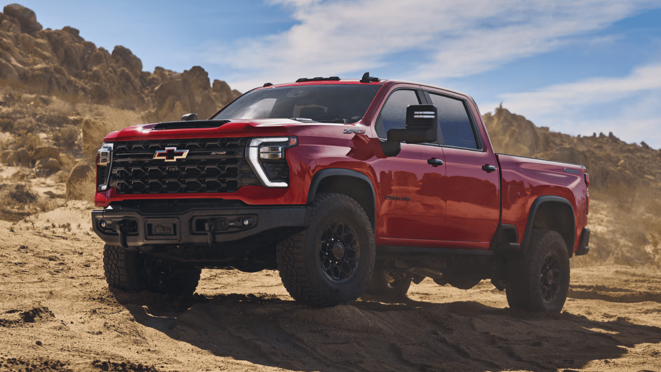 2025 Chevrolet Silverado HD off-road truck in red on rocky desert terrain