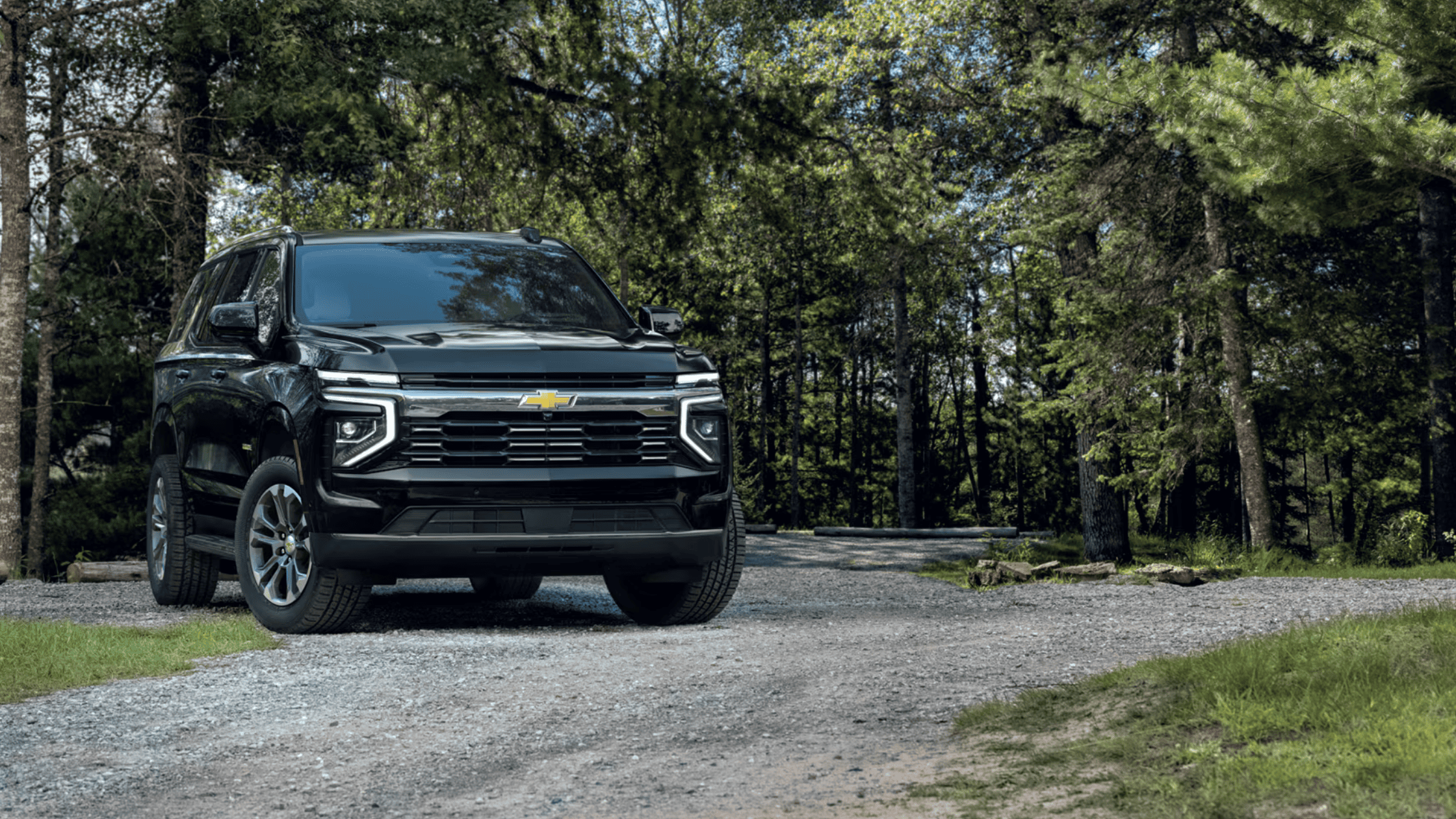 2025 Chevy Tahoe SUV parked in forest with bold front-end styling