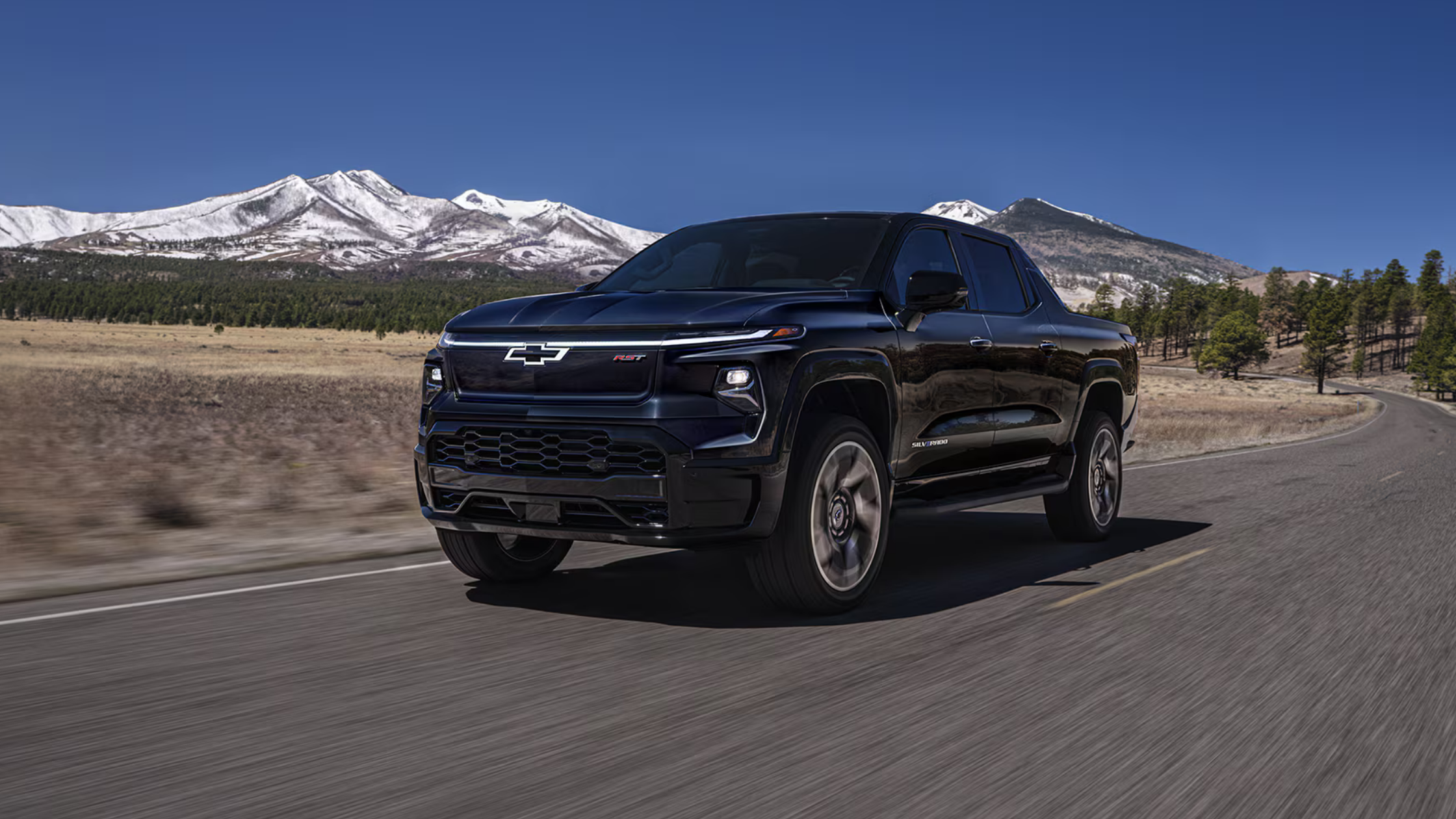 Front angle of the 2025 Chevrolet Silverado EV parked in West Jefferson, NC, showcasing its bold electric truck styling.