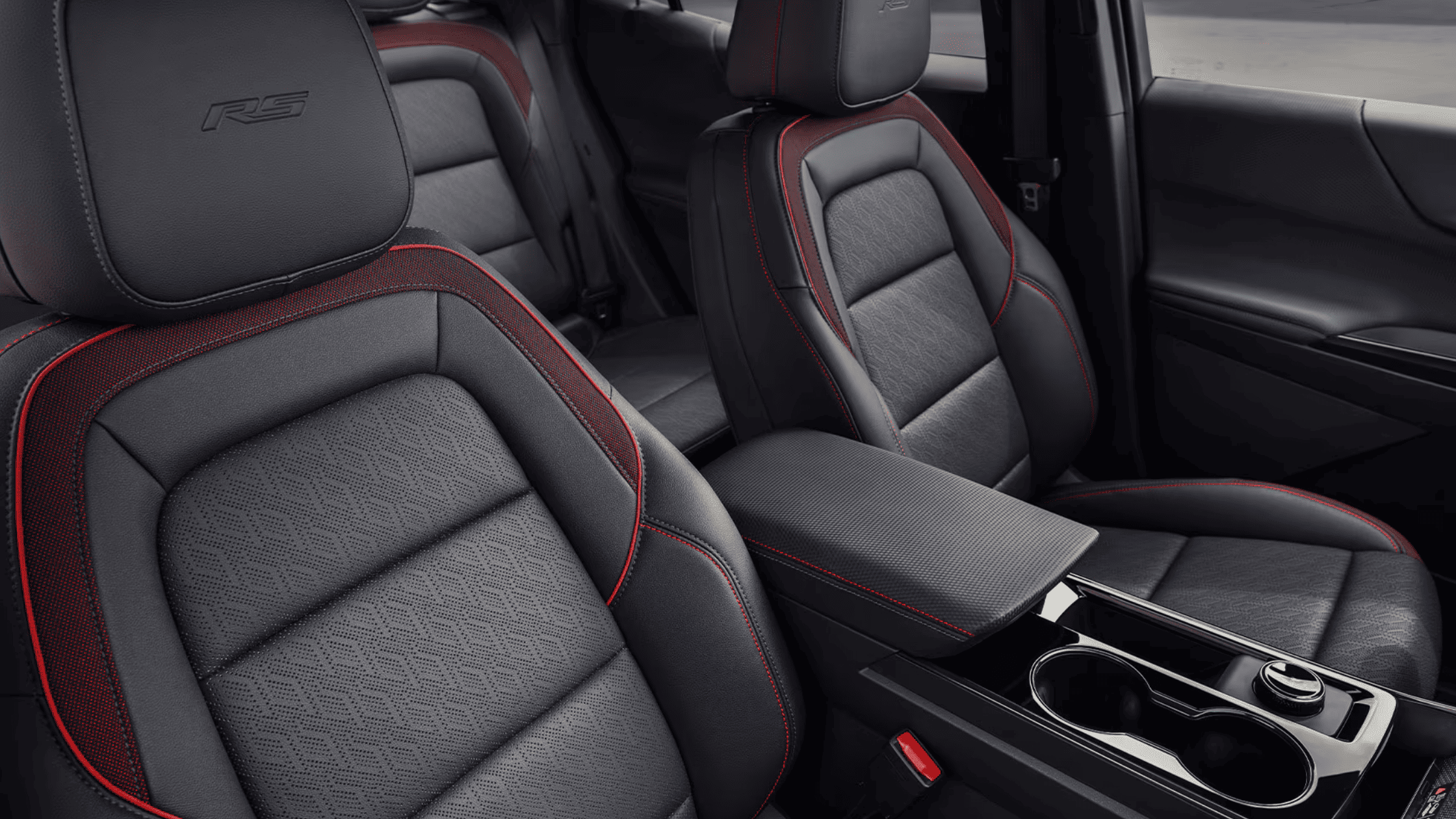 Interior of the 2025 Chevrolet Equinox showing spacious black-and-red stitched leather seating with front storage