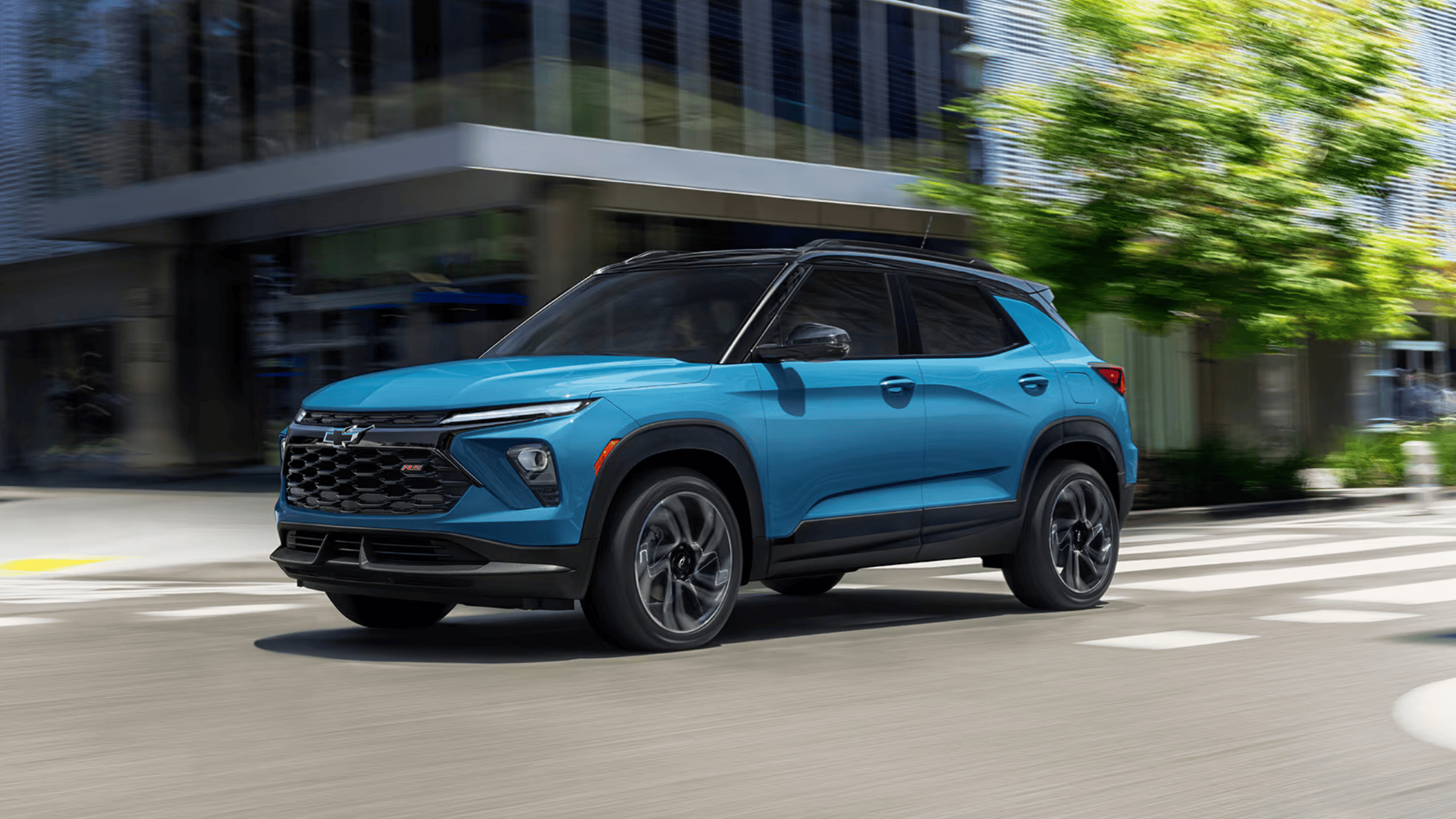 Exterior shot of the 2025 Chevrolet Trailblazer in blue driving through West Jefferson, NC city streets