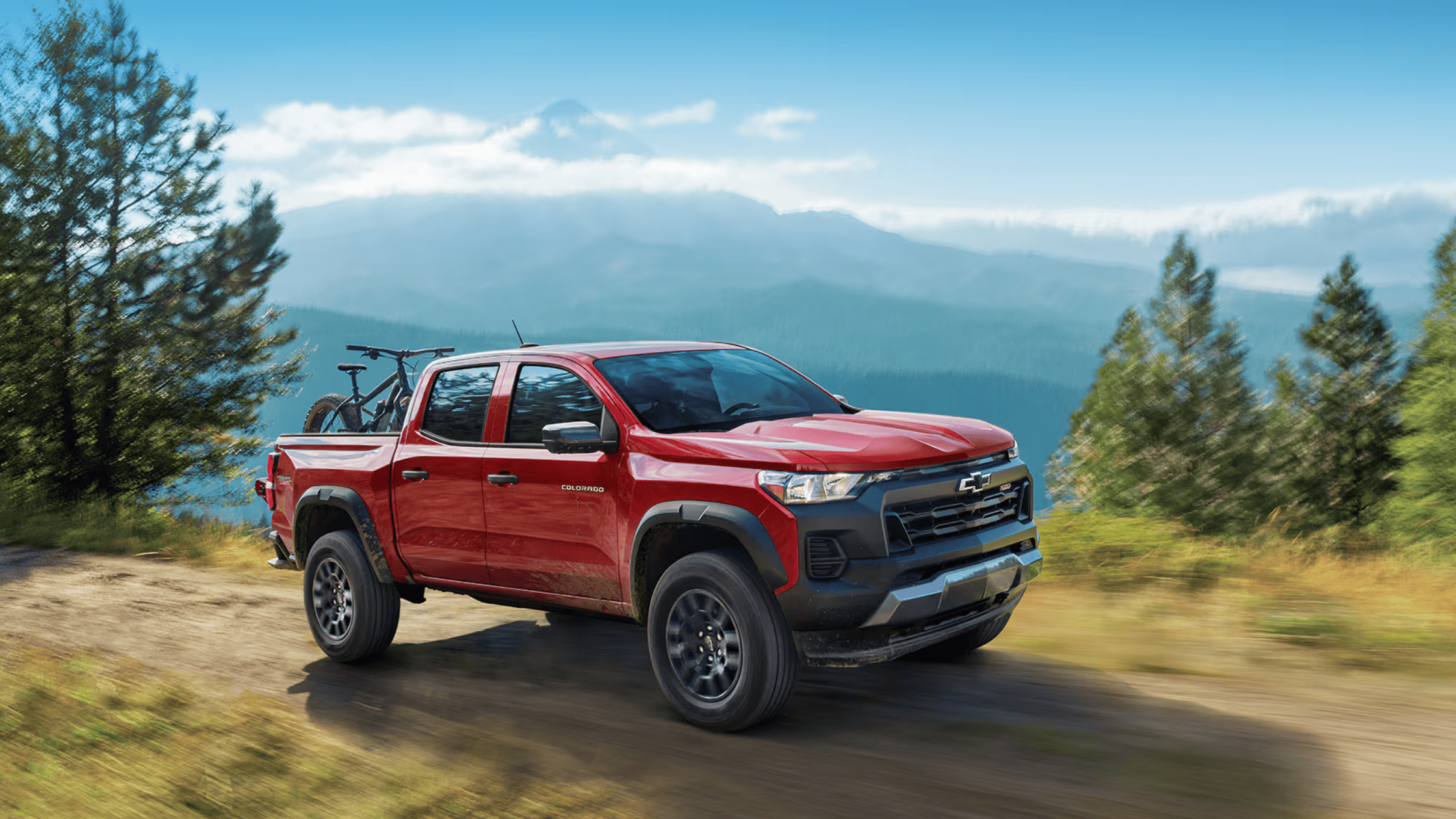 2025 Chevrolet Colorado with bikes on rack driving off-road