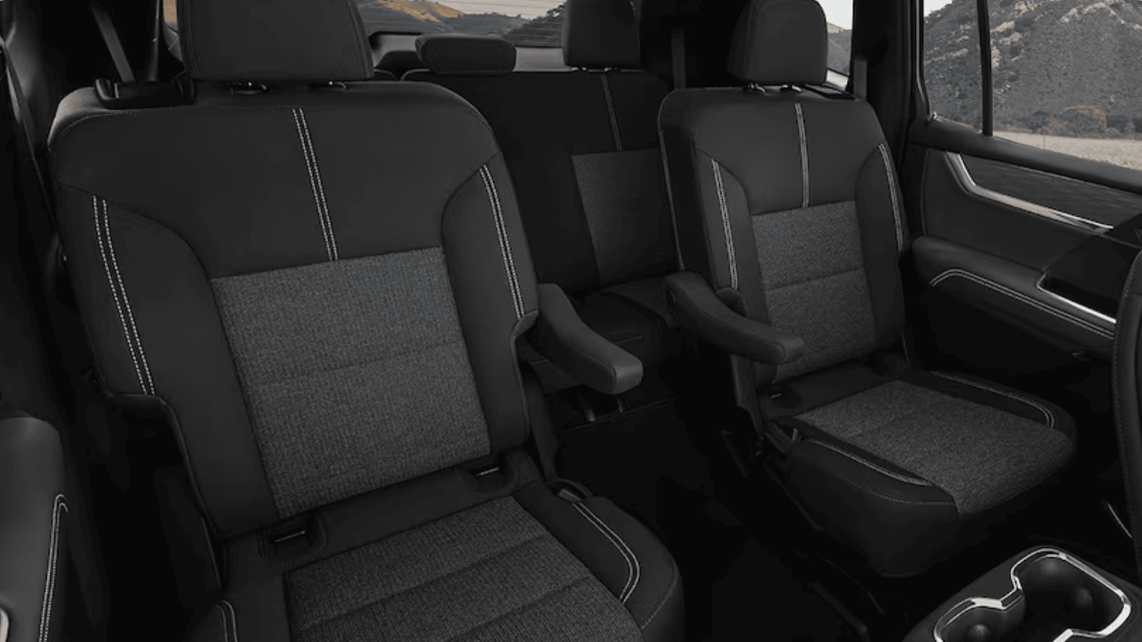 2026 GMC Acadia interior layout showing second-row seats with black and gray upholstery.