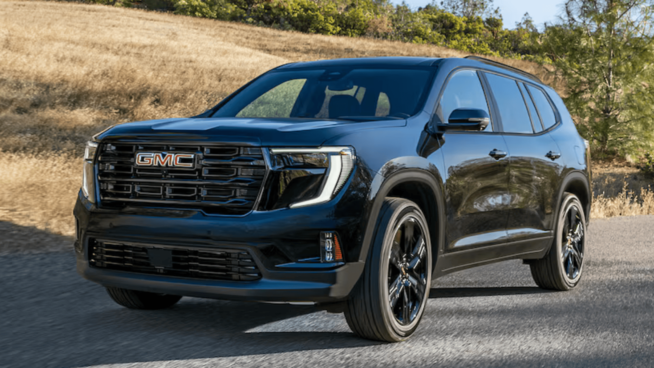 2026 GMC Acadia driving near Morganton NC with glossy black exterior.