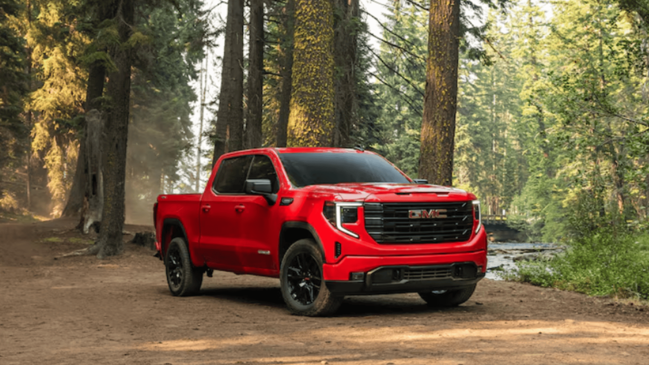 2026 GMC Sierra 1500 near Morganton, NC, parked in a forest trail setting, representing strength, capability, and rugged truck styling.