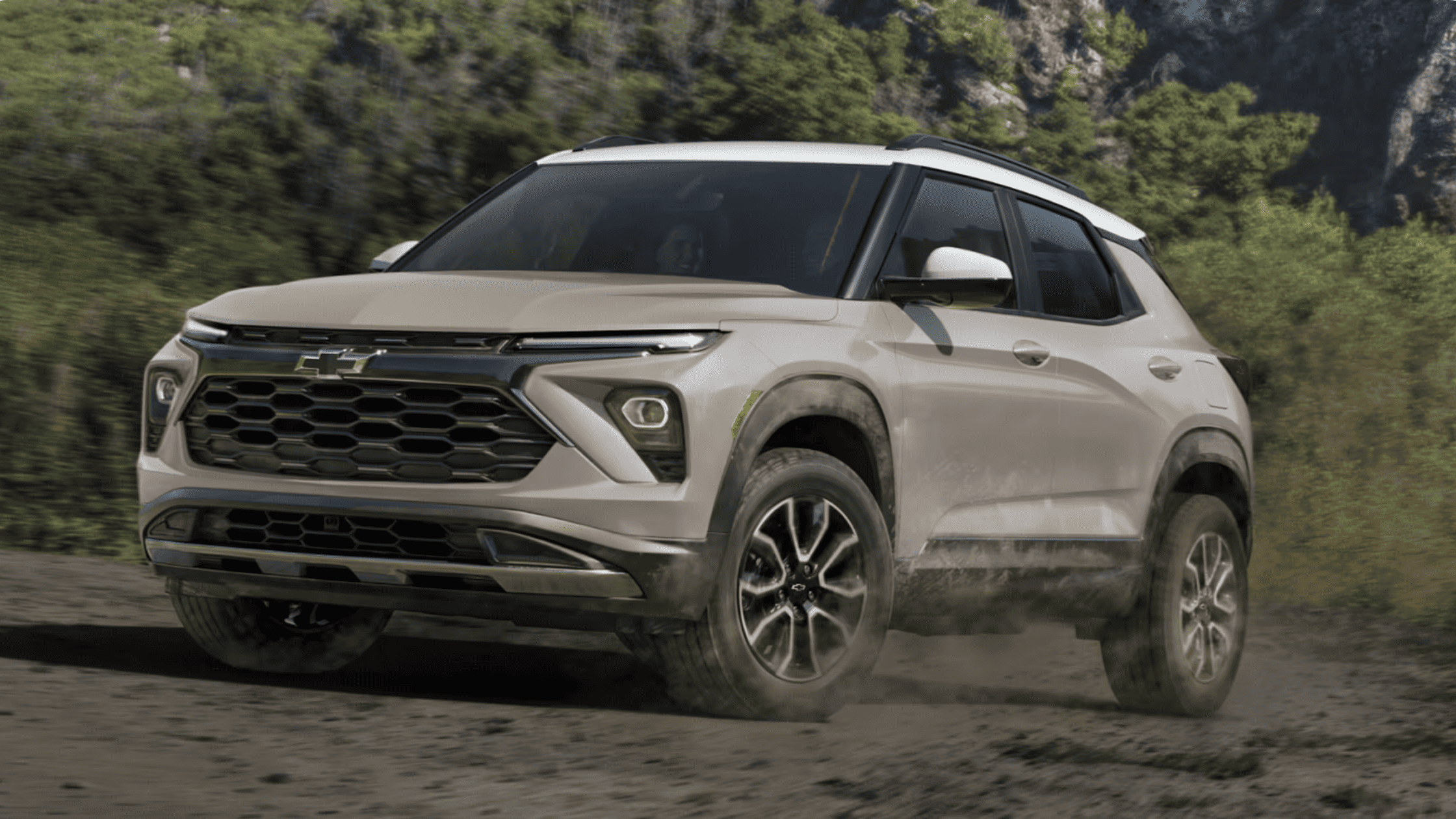 White 2026 Chevrolet Trailblazer driving on a dirt road near Boone, NC, highlighting rugged performance and SUV styling.