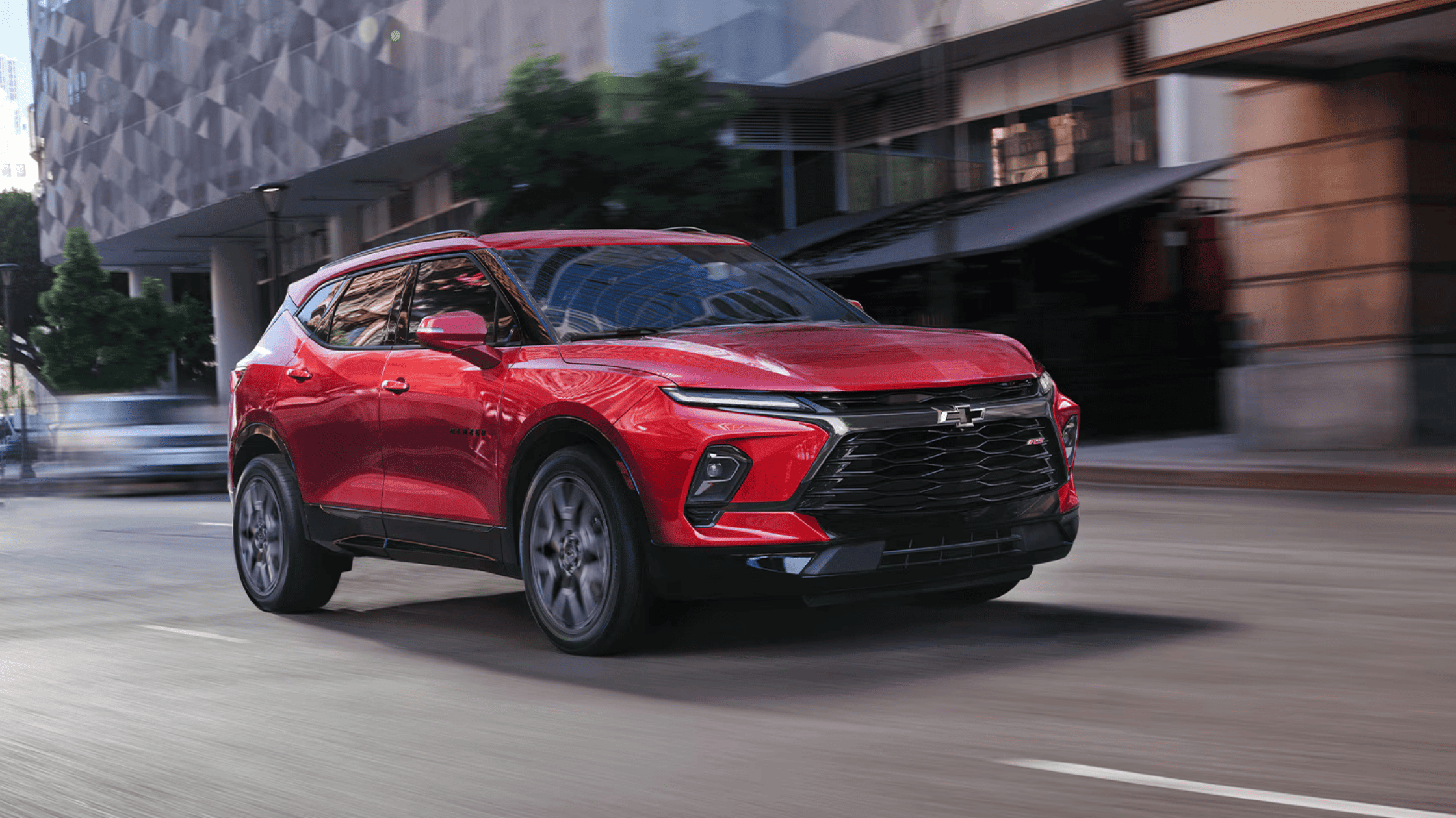 2026 Chevrolet Blazer RS in red driving through a city street in Boone, NC.