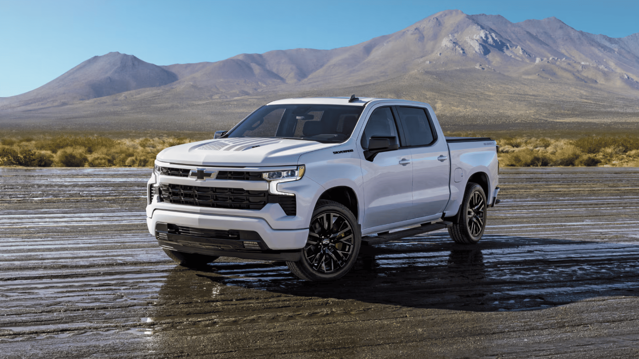 2026 Chevrolet Silverado in white with black wheels parked on a wet surface with mountain backdrop in Boone, NC.