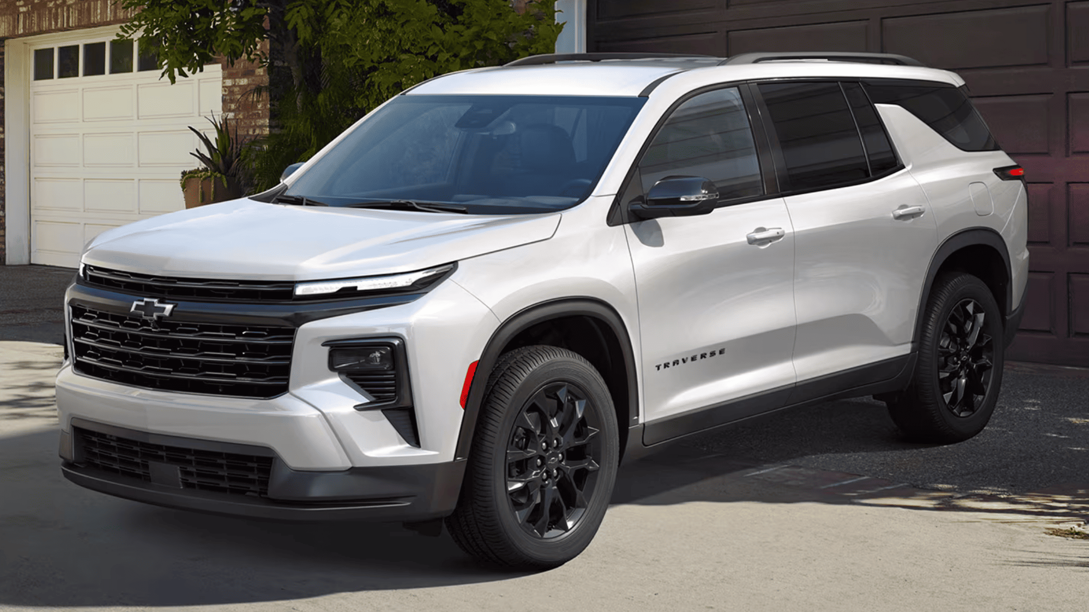 2026 Chevrolet Traverse in white with black wheels parked in a residential driveway in Boone, NC.
