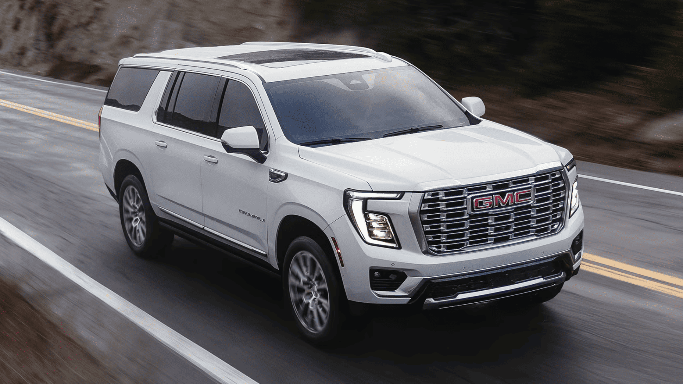 2026 GMC Yukon Denali in white driving on a mountain road in Boone, NC